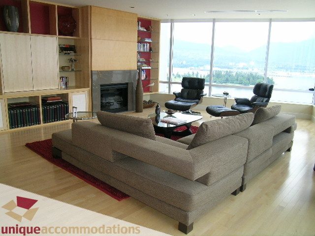 Spacious living room with a large sectional sofa, hardwood floors, and a stunning city view. - 2401 - 1077 W. Cordova Street, Vancouver Downtown