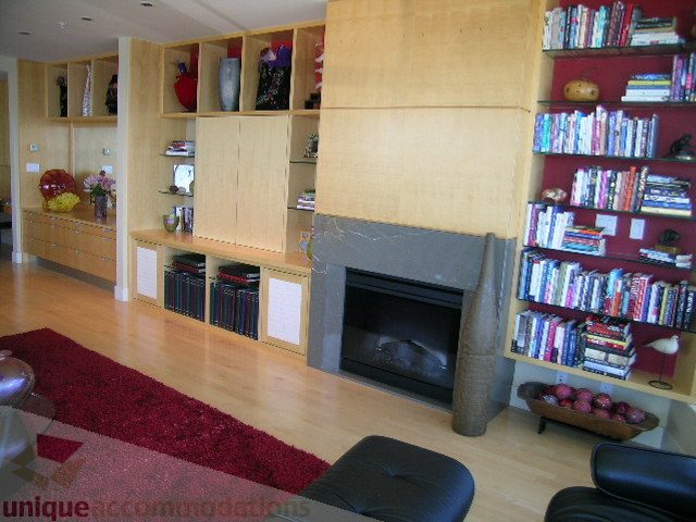 Spacious living room with hardwood floors, large bookshelves, and a cozy fireplace. - 2401 - 1077 W. Cordova Street, Vancouver Downtown