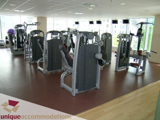 Spacious fitness room with modern equipment and large windows offering a city view. - 2401 - 1077 W. Cordova Street, Vancouver Downtown