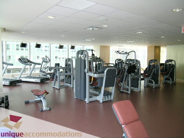 Spacious fitness room with cardio machines, weight equipment, and city view windows. - 2401 - 1077 W. Cordova Street, Vancouver Downtown