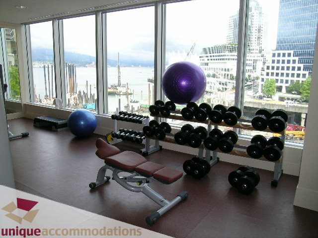 Bright fitness room with city view, modern dumbbells, and large windows. - 2401 - 1077 W. Cordova Street, Vancouver Downtown