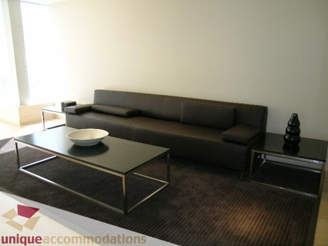 Modern living room with sleek black coffee tables and a comfortable sectional sofa, perfect for downtown Vancouver.
