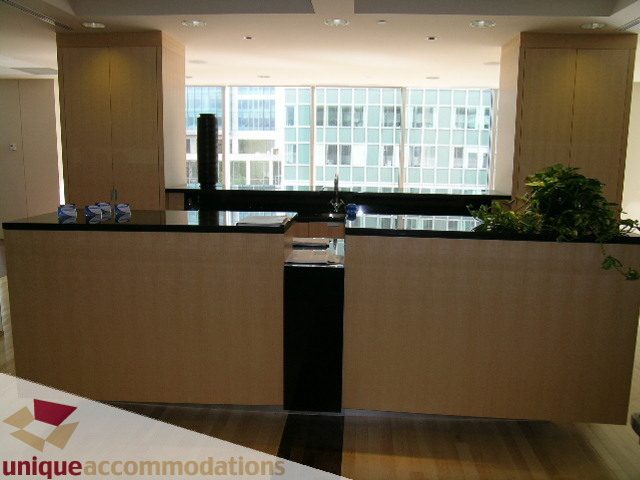 Modern kitchen with sleek black countertops, hardwood floors, and a city view. - 2401 - 1077 W. Cordova Street, Vancouver Downtown