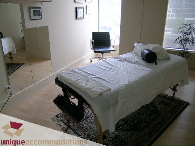 Spacious living room with a massage table, hardwood floors, and a city view. - 2401 - 1077 W. Cordova Street, Vancouver Downtown