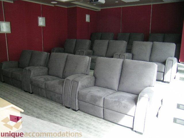 Spacious living room with plush reclining seating and red accent walls. - 2401 - 1077 W. Cordova Street, Vancouver Downtown