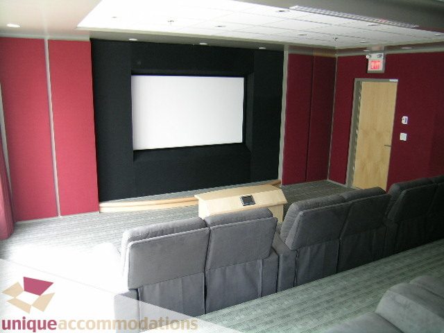 Modern living room with plush couches, large screen, and red accent walls. - 2401 - 1077 W. Cordova Street, Vancouver Downtown