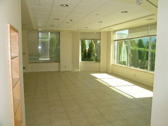 Spacious living room with large windows, tiled floor, and natural light. - 947 Huntingdon Crescent, North Vancouver