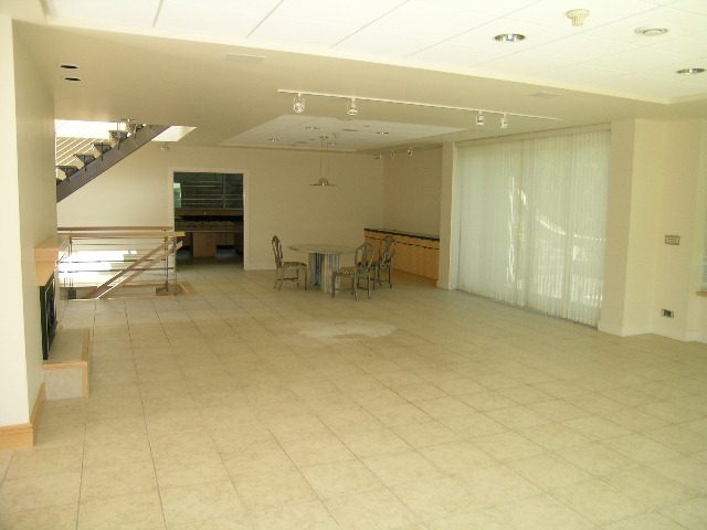Spacious living room with tiled floor, large windows, and modern lighting fixtures. - 947 Huntingdon Crescent, North Vancouver