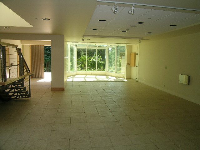 Spacious living room with large windows and tiled floors, perfect for relaxation. - 947 Huntingdon Crescent, North Vancouver