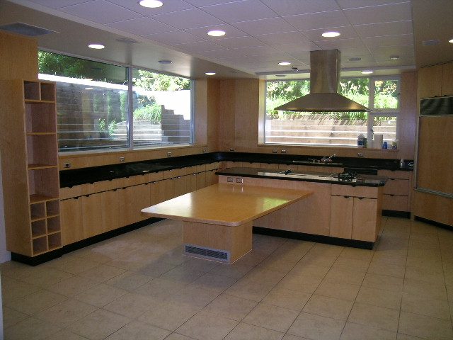 Modern kitchen with sleek countertops and large windows offering a city view. - 947 Huntingdon Crescent, North Vancouver