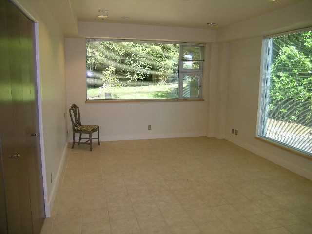 Spacious living room with large windows, natural light, and a view of greenery. - 947 Huntingdon Crescent, North Vancouver