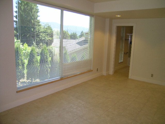 Spacious living room with large windows, hardwood floors, and a city view. - 947 Huntingdon Crescent, North Vancouver