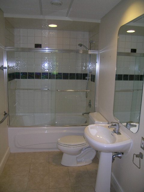 Modern bathroom with glass shower and sleek white fixtures. - 947 Huntingdon Crescent, North Vancouver