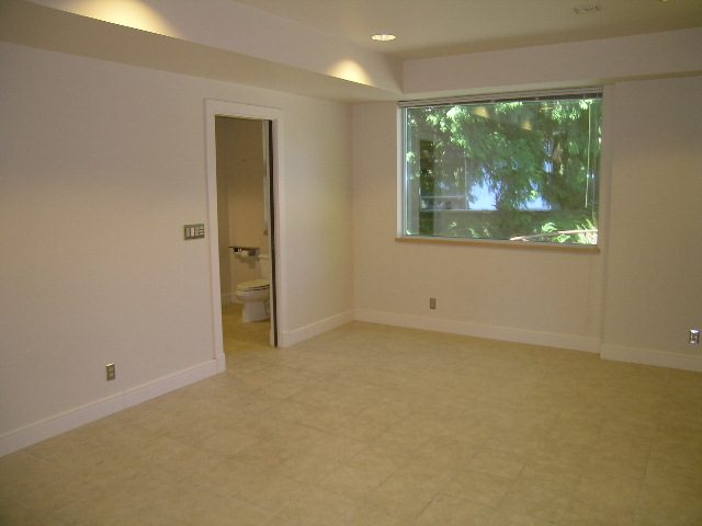 Spacious living room with large window and tiled floors, perfect for relaxation. - 947 Huntingdon Crescent, North Vancouver