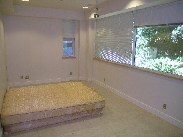 Spacious bedroom with large windows and a cozy bed, perfect for relaxation. - 947 Huntingdon Crescent, North Vancouver