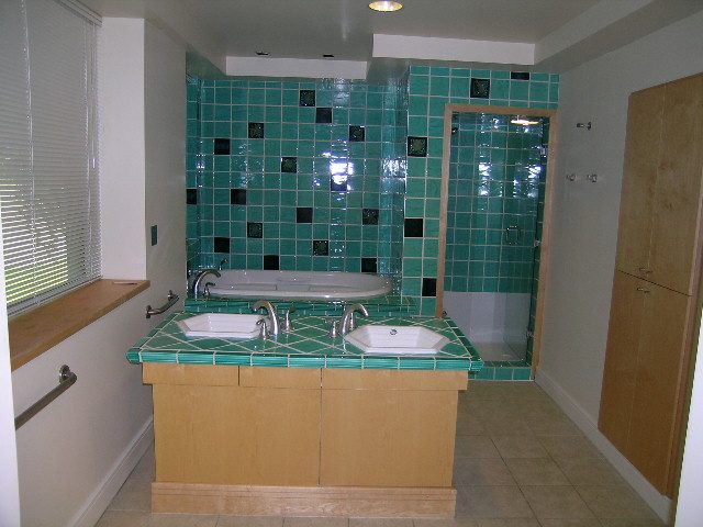 Spacious bathroom with teal mosaic tiles and dual sinks, perfect for a cozy stay. - 947 Huntingdon Crescent, North Vancouver