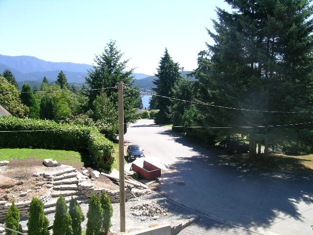 Spacious living room with a stunning view of the mountains and evergreen trees. - 947 Huntingdon Crescent, North Vancouver