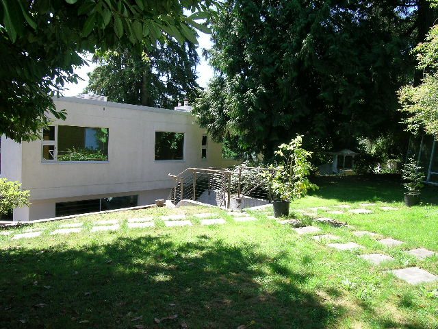 Spacious 4-bedroom house with modern design, large windows, and lush green garden. - 947 Huntingdon Crescent, North Vancouver