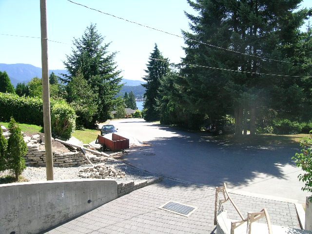 Spacious living room with a view of the forest and a stone pathway leading to the patio. - 947 Huntingdon Crescent, North Vancouver