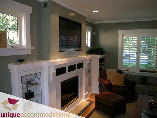Living room with fireplace, large window, and modern decor. - 815 West 23rd Street, Vancouver West Side