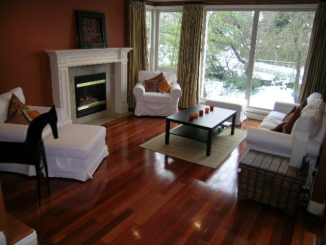 Spacious living room with hardwood floors, white furniture, and a fireplace. - 1233 11th Street, West Vancouver