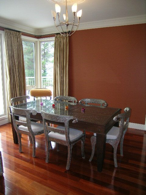 Formal dining room with hardwood floors, glass-top table, and large windows. - 1233 11th Street, West Vancouver