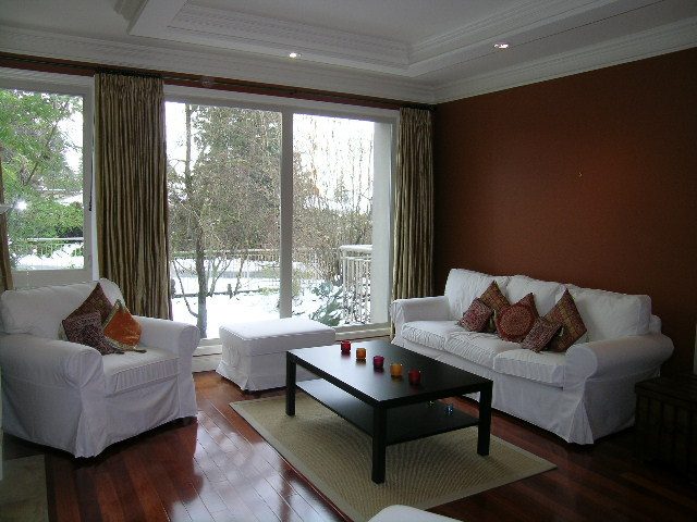 Spacious living room with large windows, hardwood floors, and white furniture. - 1233 11th Street, West Vancouver