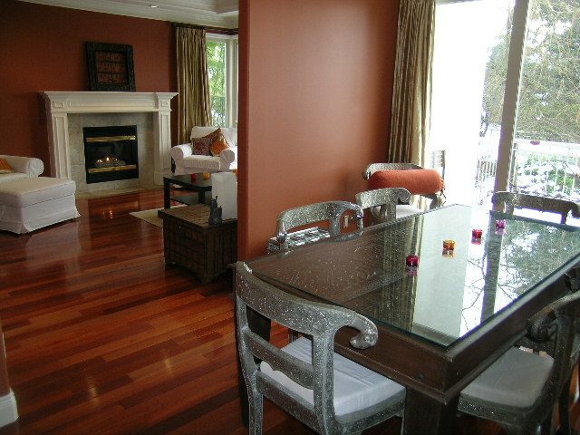 Dining area with glass table, hardwood floors, and view of trees outside. - 1233 11th Street, West Vancouver