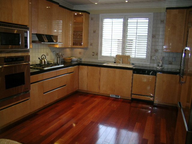 Bright kitchen with hardwood floors, stainless steel appliances, and a large window with shutters. - 1233 11th Street, West Vancouver