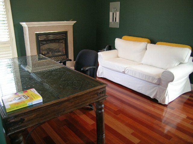 Living room with hardwood floors, white slipcovered furniture, and a fireplace. - 1233 11th Street, West Vancouver