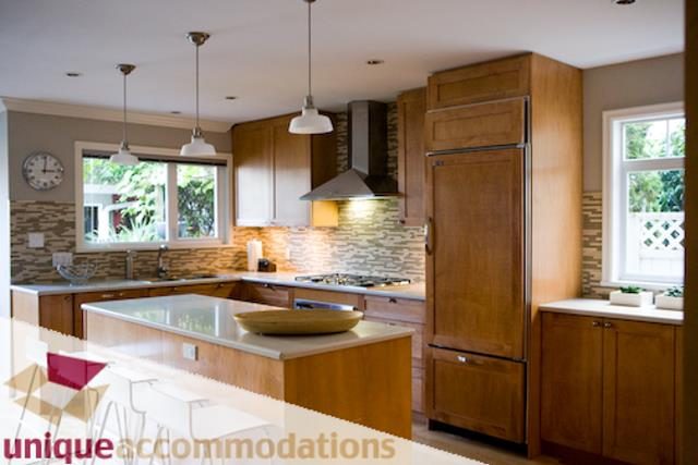 Bright kitchen with wooden cabinets, granite countertops, and a window view. - 2555 W 2nd Avenue, Vancouver West Side