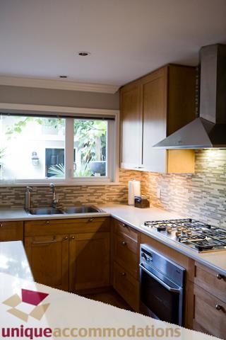 Bright kitchen with wooden cabinets, granite countertops, and a modern backsplash. - 2555 W 2nd Avenue, Vancouver West Side