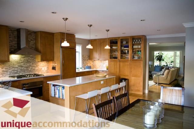 Bright kitchen with wooden cabinets, granite countertops, and hardwood floors. - 2555 W 2nd Avenue, Vancouver West Side
