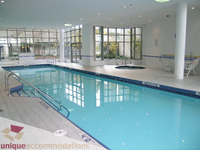 Spacious living room with large windows, modern furnishings, and a cozy fireplace. - 603 - 1328 West Pender, Vancouver Downtown
