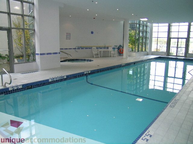 Spacious living room with large windows, modern furnishings, and a cozy fireplace. - 603 - 1328 West Pender, Vancouver Downtown