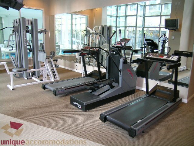 Spacious gym with treadmills, weight machines, and large windows offering a city view. - 603 - 1328 West Pender, Vancouver Downtown
