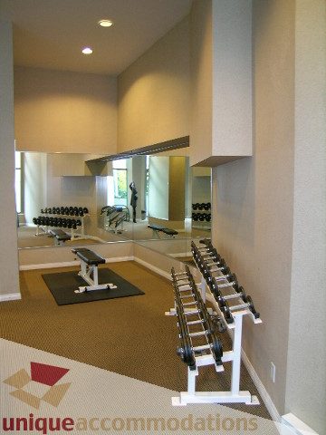 Spacious, well-lit gym with mirrored walls, dumbbells, and weight racks. - 603 - 1328 West Pender, Vancouver Downtown