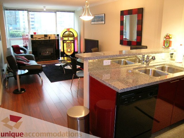 Spacious kitchen with granite countertops, hardwood floors, and a retro jukebox, perfect for a cozy downtown condo.