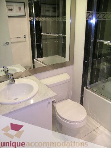 Modern bathroom with sleek white countertop and glass shower enclosure. - 603 - 1328 West Pender, Vancouver Downtown
