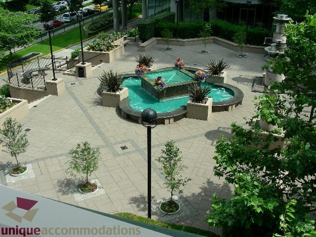 Spacious 1-bedroom + den condo with a serene courtyard featuring a fountain and lush greenery. - 603 - 1328 West Pender, Vancouver Downtown