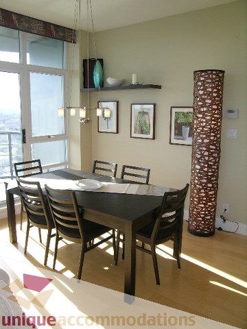 Spacious dining area with hardwood floors, modern pendant lights, and a city view. - 3005 - 1483 Homer Street, Vancouver Downtown