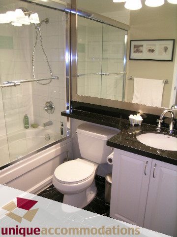 Spacious bathroom with black granite countertops and a glass-enclosed shower. - 306 - 588 Broughton Street, Vancouver Downtown