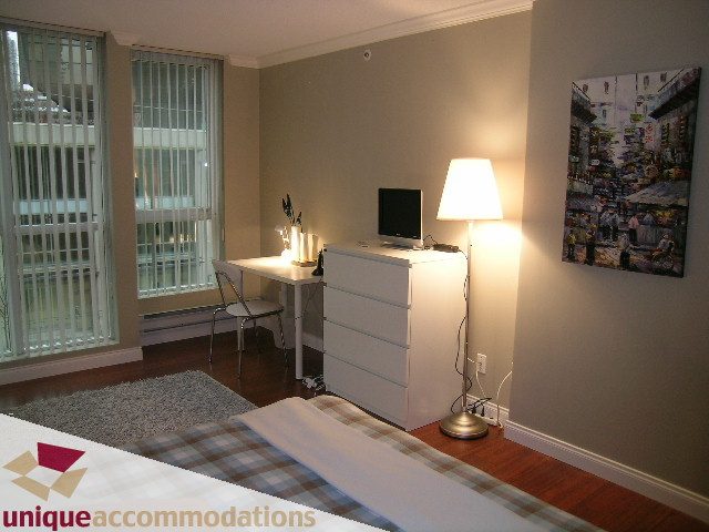 Cozy 1-bedroom + den condo with hardwood floors, city view, and a modern desk setup. - 306 - 588 Broughton Street, Vancouver Downtown