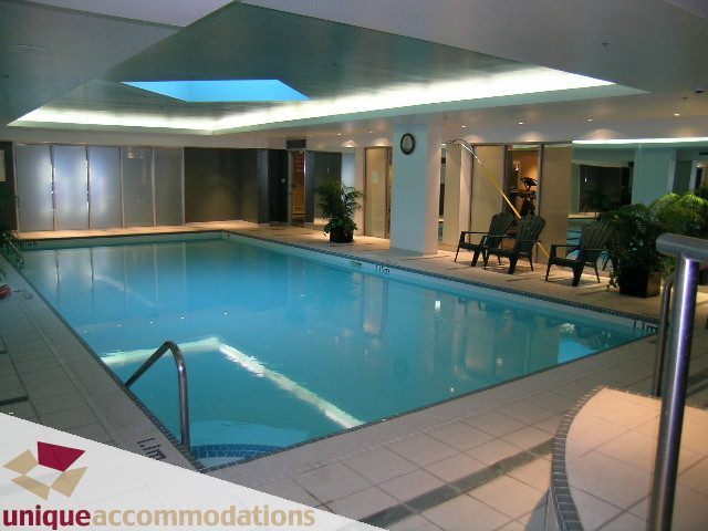 Spacious, modern 1-bedroom + den condo with a luxurious indoor pool, sleek tile flooring, and ample natural light.