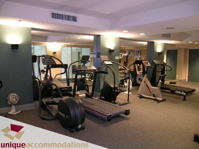 Modern fitness room with cardio equipment and large mirrors. - 306 - 588 Broughton Street, Vancouver Downtown