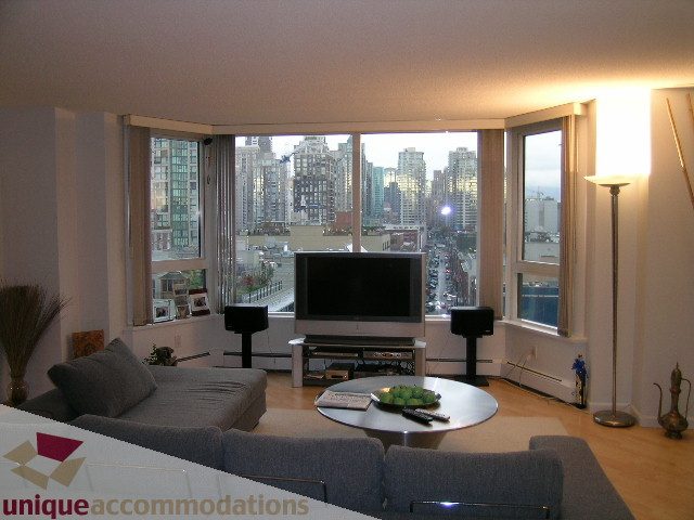 Spacious living room with hardwood floors, city view, and modern furnishings. - 1306-388 Drake St, Vancouver Downtown