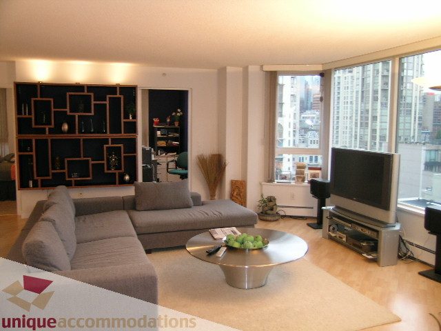 Spacious living room with modern furniture, hardwood floors, and a city view. - 1306-388 Drake St, Vancouver Downtown