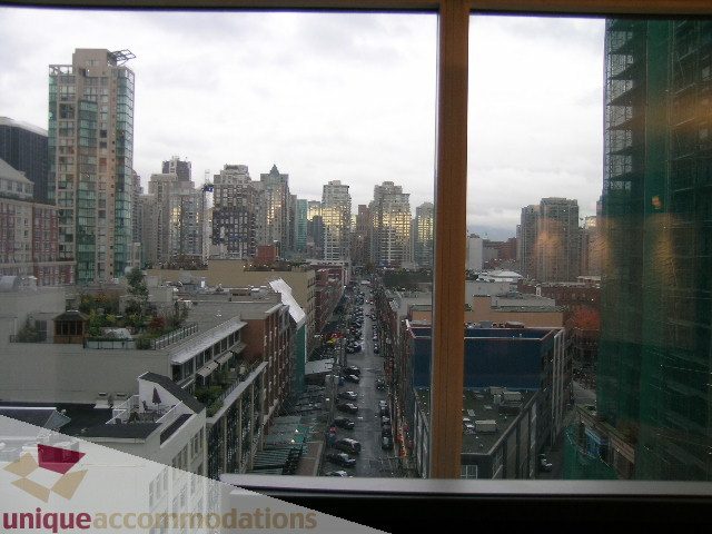 Spacious 2-bedroom + den condo with stunning city view, featuring modern furnishings and large windows. - 1306-388 Drake St, Vancouver Downtown