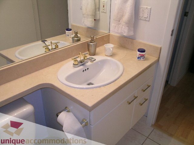 Spacious bathroom with beige countertops and modern sink fixtures, showcasing a clean and inviting design. - 1306-388 Drake St, Vancouver Downtown