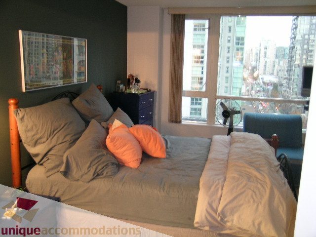 Spacious bedroom with city view, cozy bedding, and modern decor. - 1306-388 Drake St, Vancouver Downtown